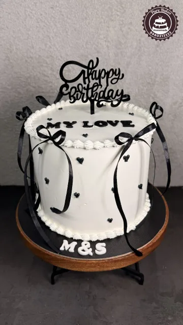 Elegant Black and White Anniversary Cake with Ribbon Decor