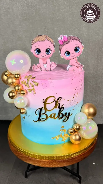 Pink and blue first birthday cake decorated with baby toppers, balloons, gold accents, and Oh Baby lettering